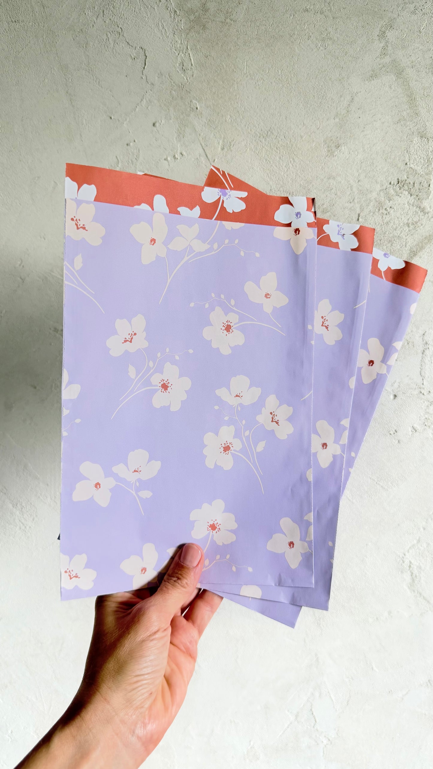 Geschenktüten in Flieder mit cremefarbenen Blüten und korallfarbenem Innendruck, 17 x 25 cm