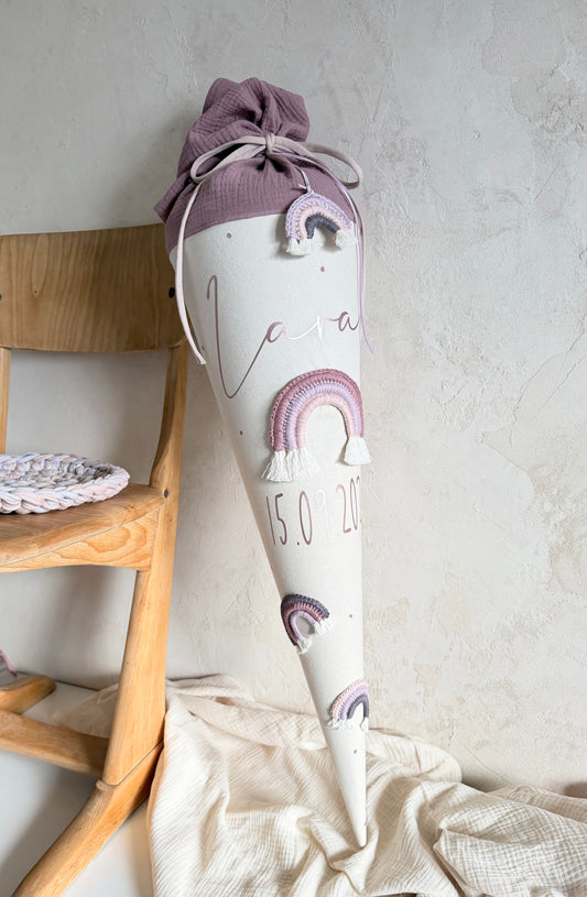 Personalisierte Regenbogen-Schultüte in Mauve, Flieder und Rosé am Holzstuhl