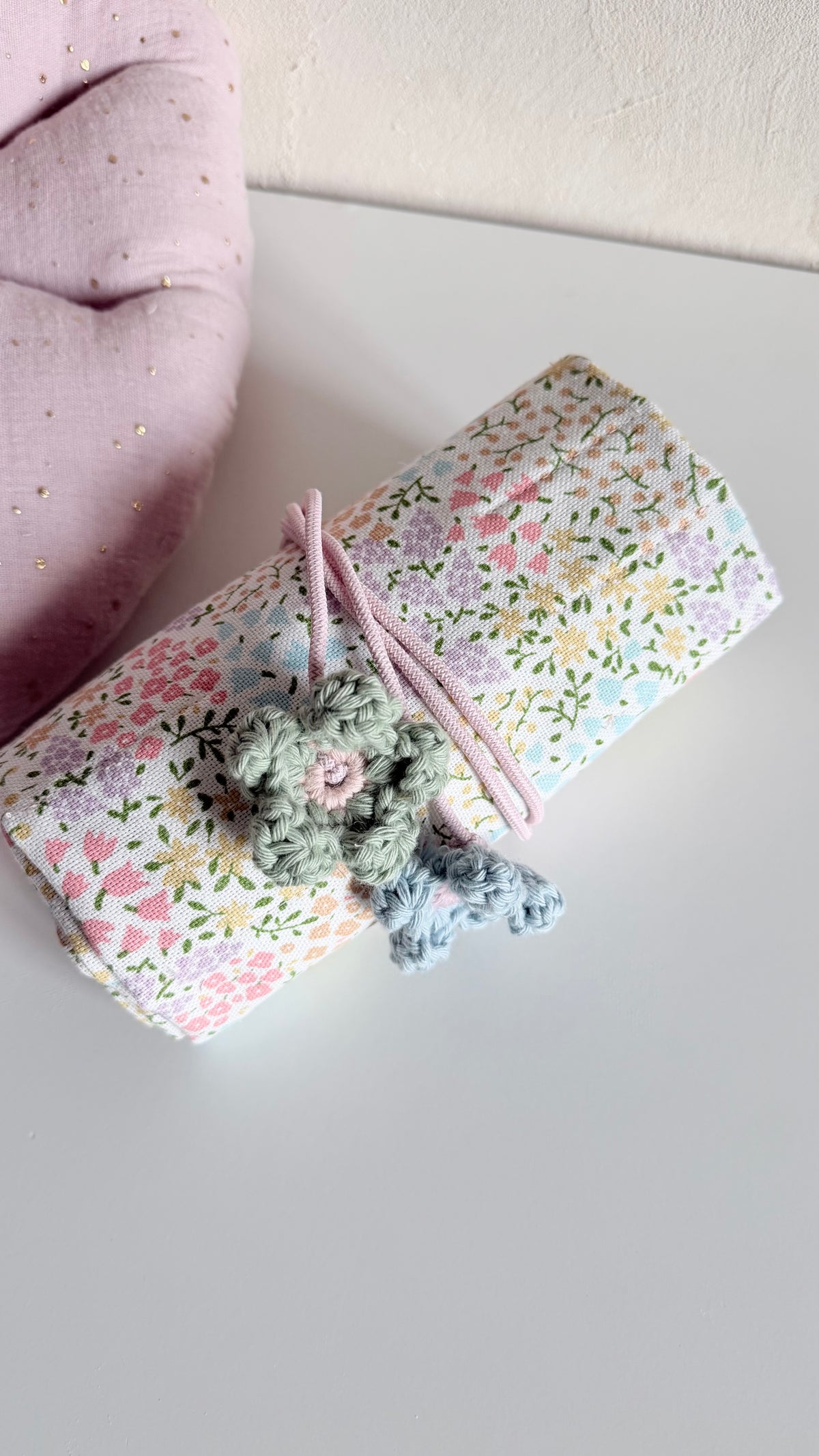 Waldorf-Rollmäppchen aus geblümtem Canvas, gerollt und mit rosafarbener Kordel verschlossen