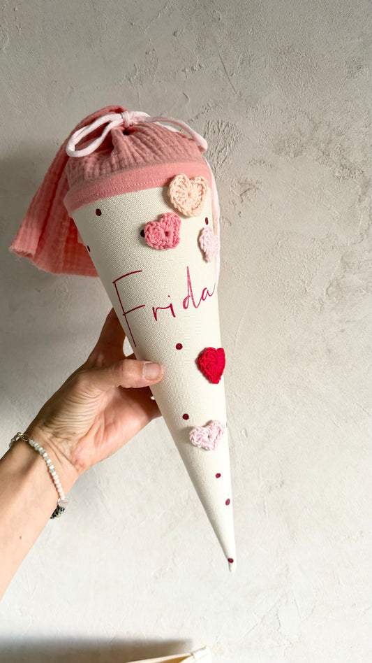 Personalisierte Kindergartentüte mit Häkelherzen und Beispielname Frida, in der Hand gehalten