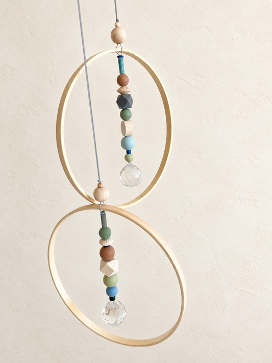 Zwei Bambusring-Suncatcher in Naturfarben vor ruhiger heller Wand. KI-bearbeitete Produktdarstellung; Originalfotos in der Galerie.