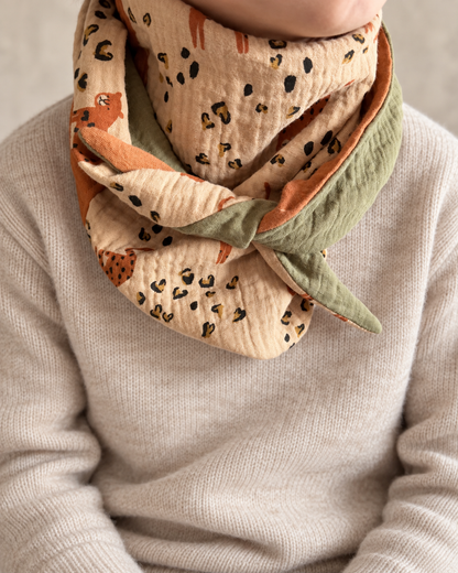 KI-bearbeitetes Tragebild: Wendehalstuch Dschungelliebe an einem Kind mit beigem Strickpullover