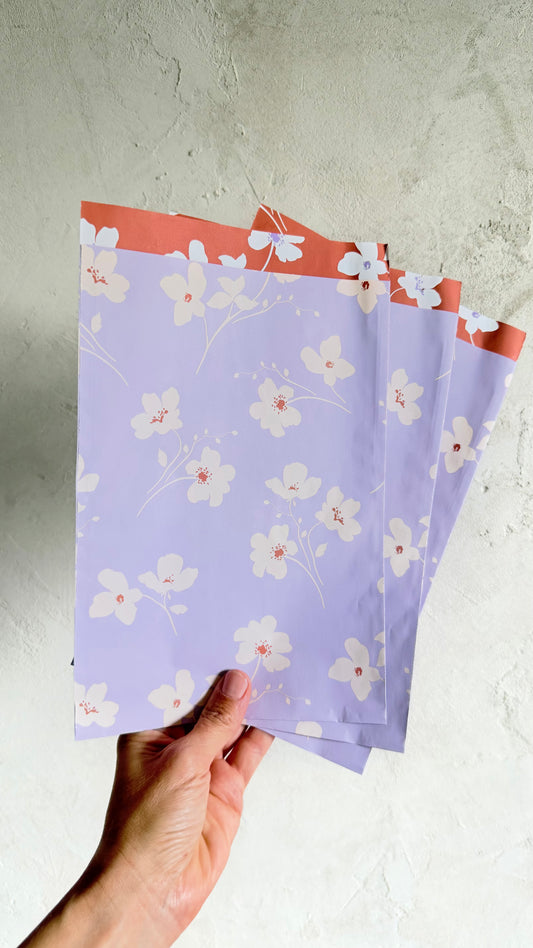 Geschenktüten in Flieder mit cremefarbenen Blüten und korallfarbenem Innendruck, 17 x 25 cm