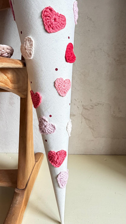 Gehäkelte Herzen in Rot, Rosé und Pink an der Stoffschultüte